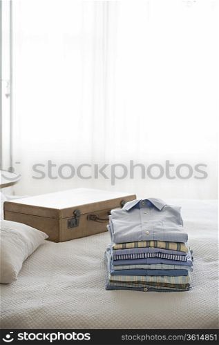Ironed and folded shirts next to a suitcase