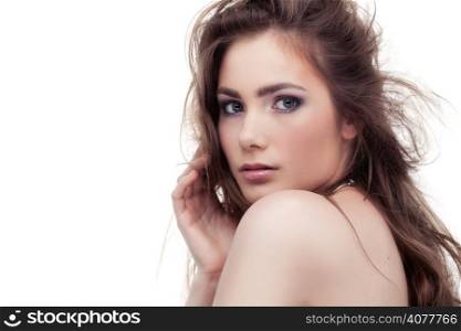 Irresistible woman looks over her shoulder touching her hair isolated on white