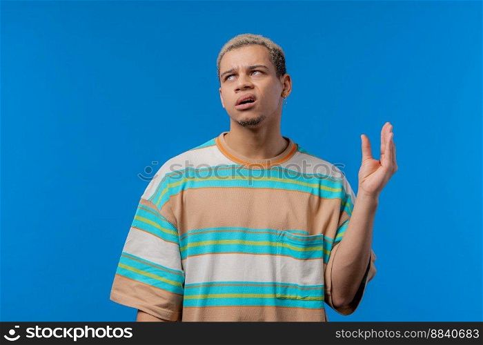 Irritated american man showing bla-bla-bla gesture with hands, rolling eyes on blue background. Empty promises, blah concept. Lier. High quality photo. Irritated american man showing bla-bla-bla gesture with hands, rolling eyes on blue background. Empty promises, blah concept. Lier.