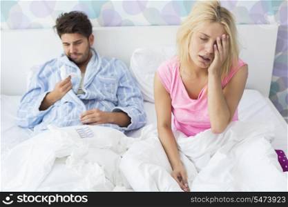 Irritated sick couple on bed at home