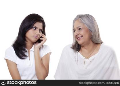 Irritated teenage girl looking at her grandmother