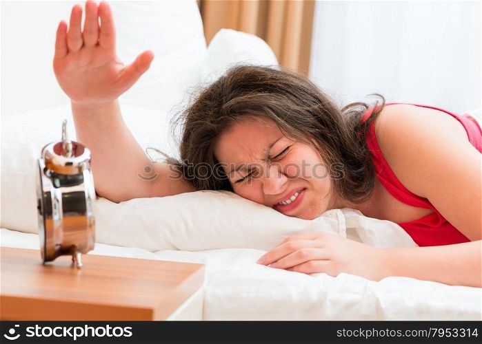 irritated woman off the alarm that prevent sleep
