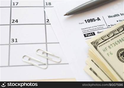 IRS Form 1095-A Health Insurance Marketplace Statement tax blank lies with pen and many hundred dollar bills on calendar page. Tax period concept. Copy space for text. IRS Form 1095-A Health Insurance Marketplace Statement tax blank lies with pen and many hundred dollar bills on calendar page