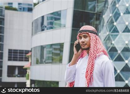 Islamic man using smartphones app organize schedule agenda  focus on hands holding smartphone muslim modern uae city. Arab men wear hijab and muslim formal dress sending text sms online lifestyle