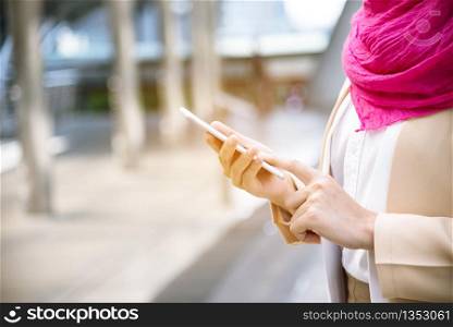 Islamic woman using smartphones app organize schedule agenda focus on hands holding smartphone muslim modern uae city. Arab woman wear hijab and muslim formal dress sending text sms online lifestyle