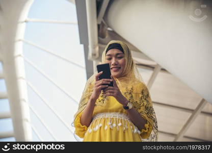 Islamic woman using smartphones app organize schedule agenda focus on hands holding smartphone muslim modern uae city. Arab woman wear hijab and muslim formal dress sending text sms online lifestyle