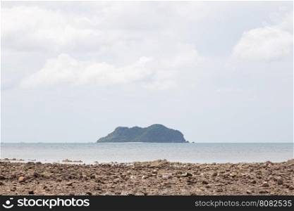 Island and sandy beaches. Large island in the middle of the sea. In front of a beach with small stones.
