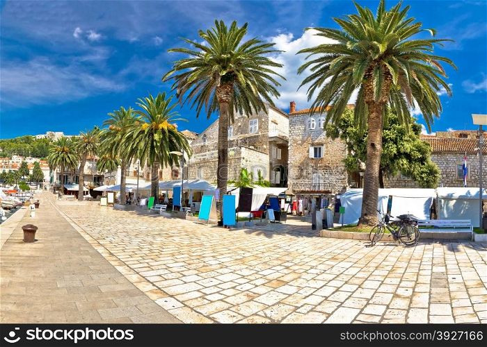 Island of Hvar palm waterfront with old stone architecture and walkway, Dalmatia, Croatia