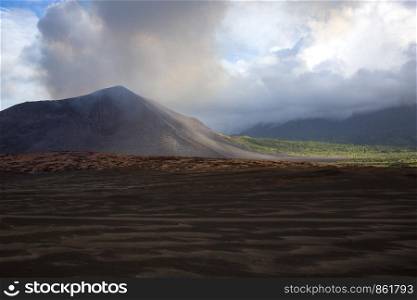 Island Tanna with smoking volcanic cone and scorched earth