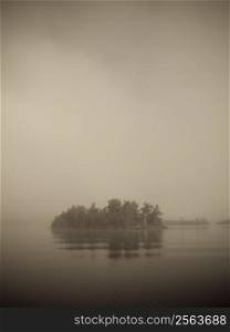 Islet on the Lake of the Woods covered in mist, Ontario, Canada
