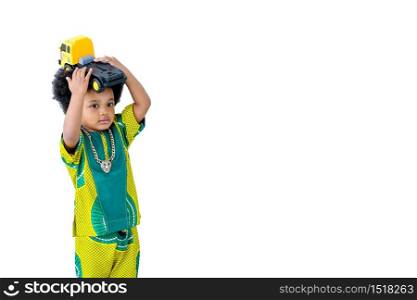 Isolated African young boy holds yellow truck toy over his head with white background.
