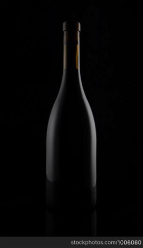 Isolated black matt wine bottle on dark background.. Isolated black matt wine bottle on dark background