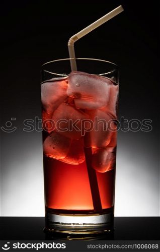 Isolated glass with a red cocktail and ice-cubes.. Isolated glass with a red cocktail and ice-cubes