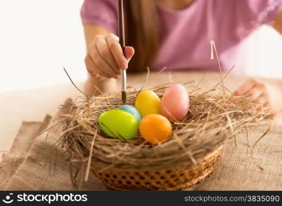 Isolated photo of girl painting Easter eggs