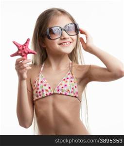 Isolated portrait of cute smiling girl in sunglasses posing with starfish
