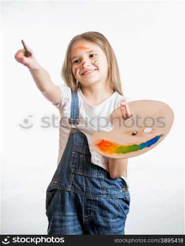 Isolated portrait of drawing little girl holding palette with paints
