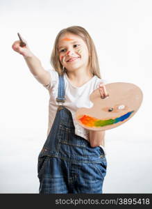 Isolated portrait of drawing little girl holding palette with paints