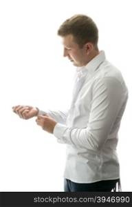 Isolated portrait of stylish man getting ready and buttoning shirt sleeves