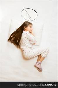 Isolated shot from top view of cute girl sleeping on big cushion with speech bubble
