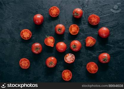 Isolated shot of cherry heirloom tomatoes with green leaves on dark background. Organic food. Harvesting and healthy eating concept
