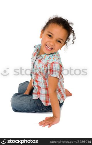 Isolated studio shot of a beautiful mixed race littkle girl sitting and laughing