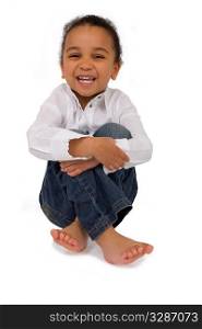 Isolated studio shot of a beautiful mixed race littkle girl sitting cross legged and laughing