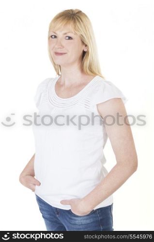Isolated white background studio photograph of happy smiling middle aged blond woman in blue denim jeans and white shirt