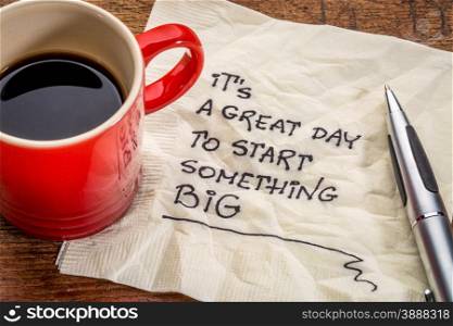 It is a great day to start something big - motivational handwriting on a napkin with a cup of coffee