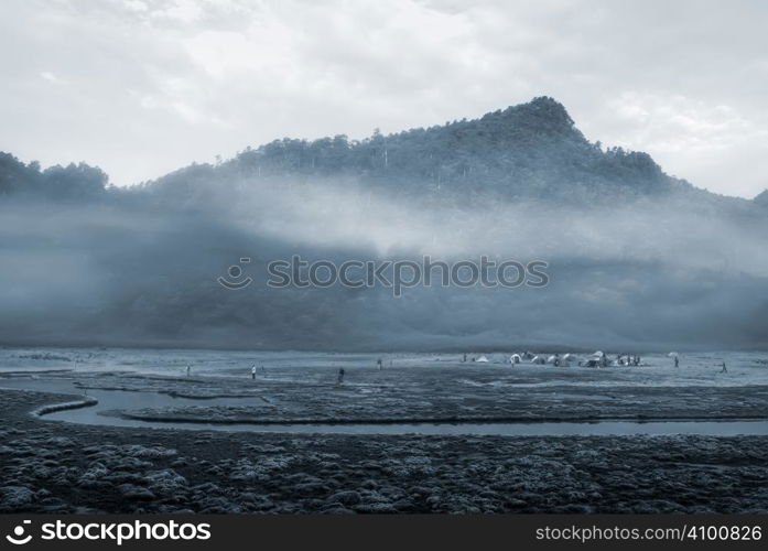 It is a river with mist and mountain.