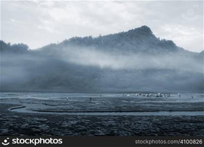It is a river with mist and mountain.