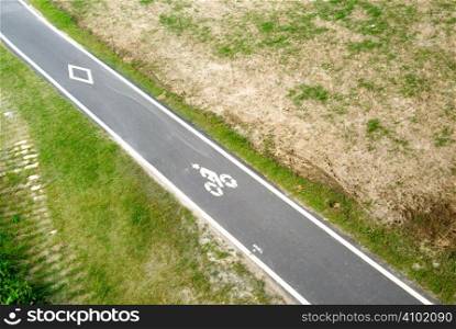 It is a road for bicycle on the grassland.