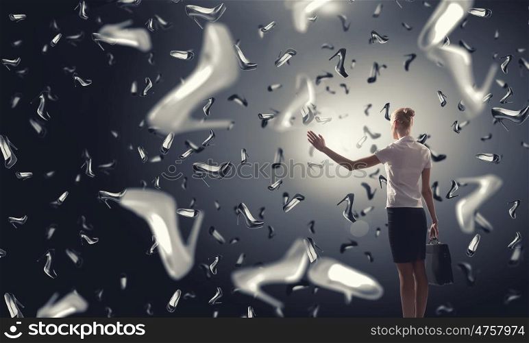 It is rainning shoes. Beautiful young woman in suit and falling shoes