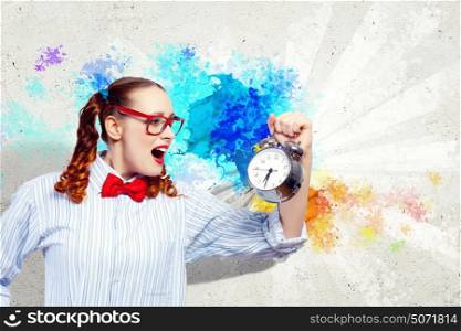 it is time!. Young woman with an old-fashioned alarm clock