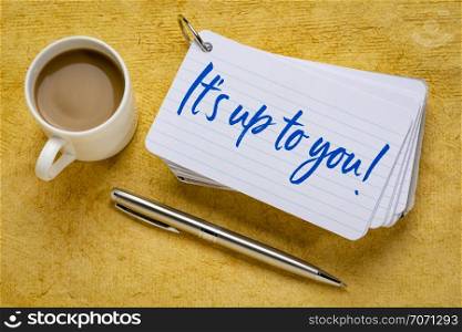 It is up to you! Handwriting on a stack of index cards with a cup of coffee and a pen against yellow textured paper