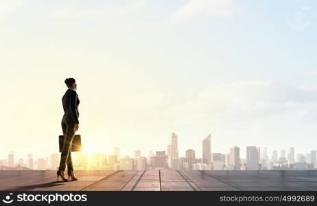 It&rsquo;s a new day. Rear view of businesswoman against sunrise scene