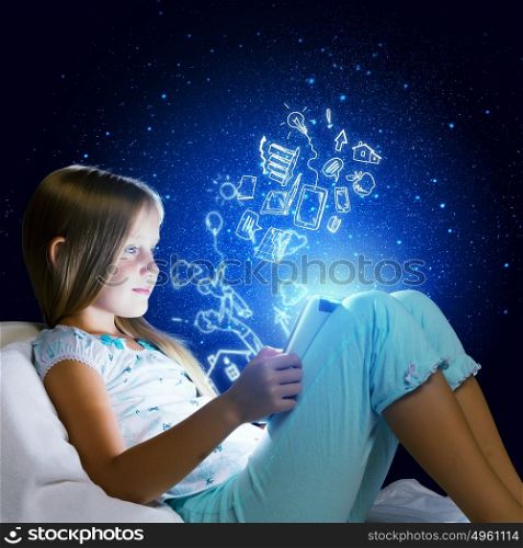 It&rsquo;s bedtime. Girl sitting in bed and using tablet pc
