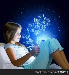 It&rsquo;s bedtime. Girl sitting in bed and using tablet pc