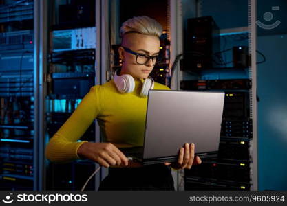 IT woman connecting internet network cable to laptop in dark server room. Communication technology concept. IT woman connecting internet network cable to laptop in server room