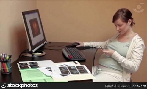 italian 6 months pregnant woman watching ultrasound pictures of her baby on pc.