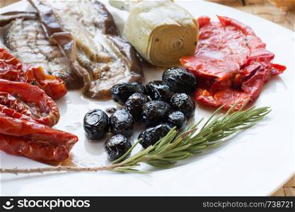 Italian antipasti as dinner appetizer. Tomatoes, Olives, paprika and more.