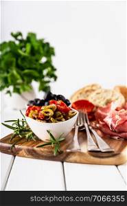 Italian antipasti with mediterranean olives, parma ham, salami and ciabatta bread