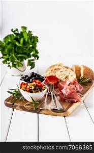Italian antipasti with mediterranean olives, parma ham, salami and ciabatta bread