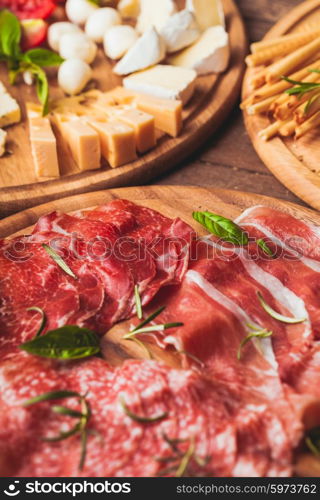 Italian appetizer - various types of ham, cheese and grissini