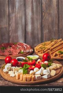 Italian appetizer - various types of ham, cheese and grissini with copy space on the wall