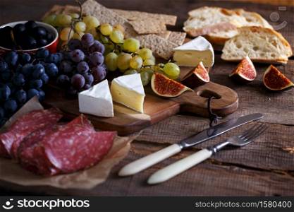 italian breakfast - grapes, brie cheese, salami, figs and olives