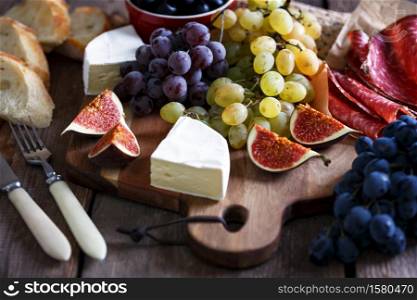 italian breakfast - grapes, brie cheese, salami, figs and olives