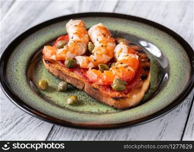 Italian bruschetta with shrimps and capers on serving plate