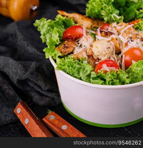 Italian Caesar salad with chicken, Parmesan and crackers, in a craft cardboard container for delivery