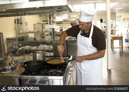 Italian checking stirring in his pasta sauce