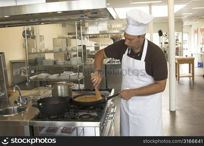 Italian checking stirring in his pasta sauce